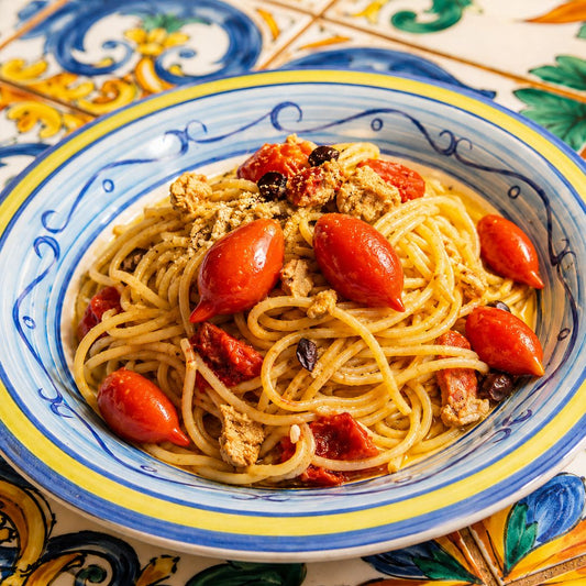 Spaghetti di Gragnano con pomodori Spunzillo, su tavolo in ceramica vietrese.
