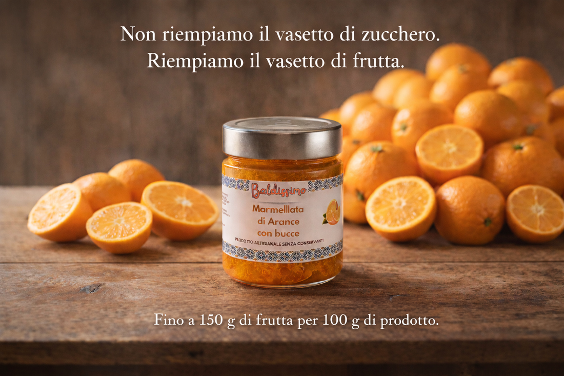 Vasetto di marmellata artigianale di arance con bucce Baldissimo su tavolo in legno, circondato da arance fresche.