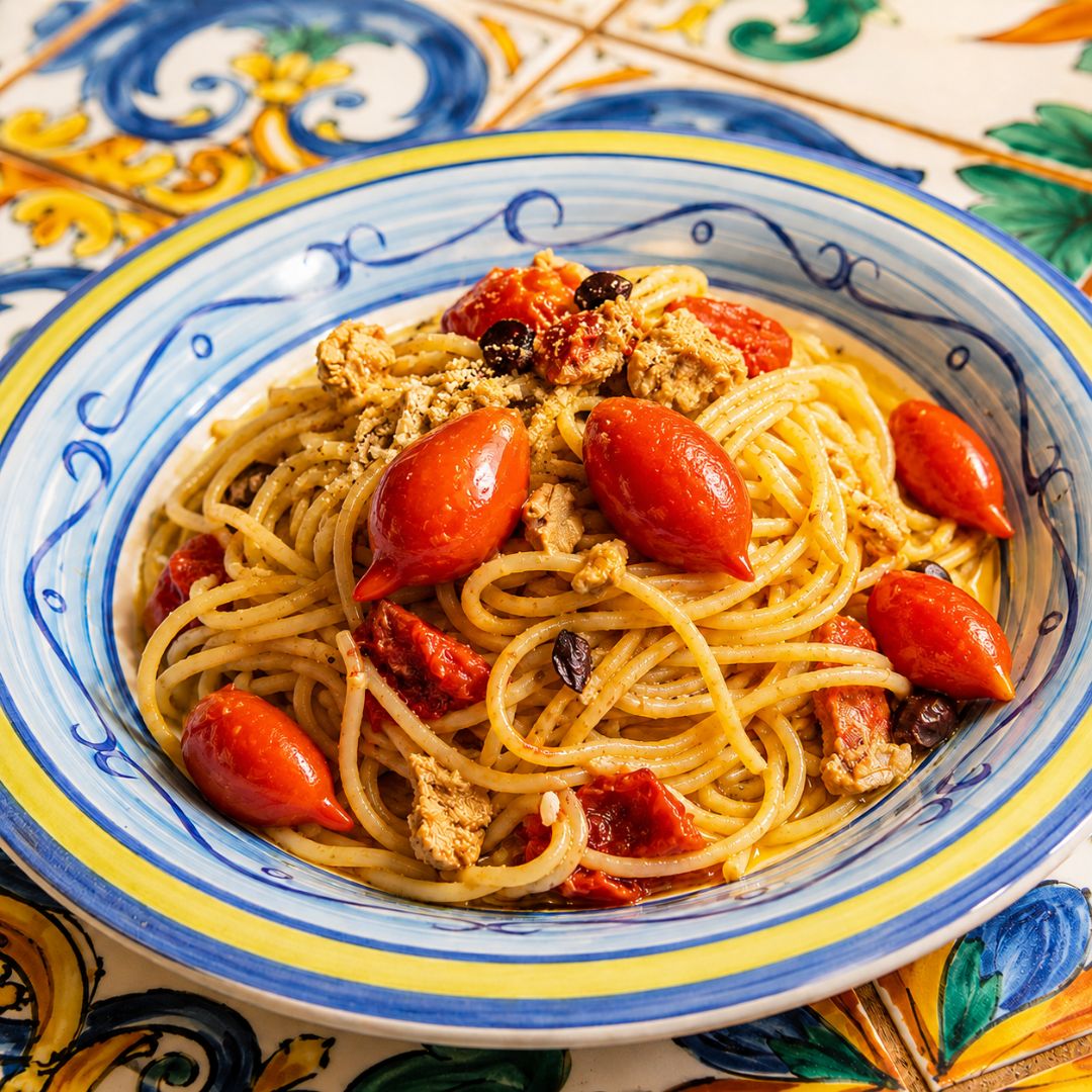 Spaghetti di Gragnano con pomodori Spunzillo, su tavolo in ceramica vietrese.