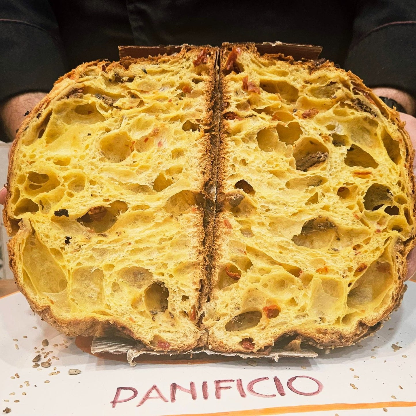 Pan del Golfo aperto con alveolatura interna, pomodori secchi e alici di Cetara